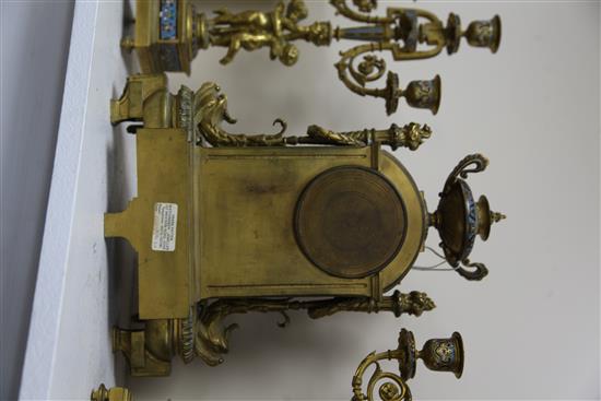 A third quarter of the 19th century French champlevé enamel and ormolu clock garniture, height clock 14in. candelabra 14.75in.